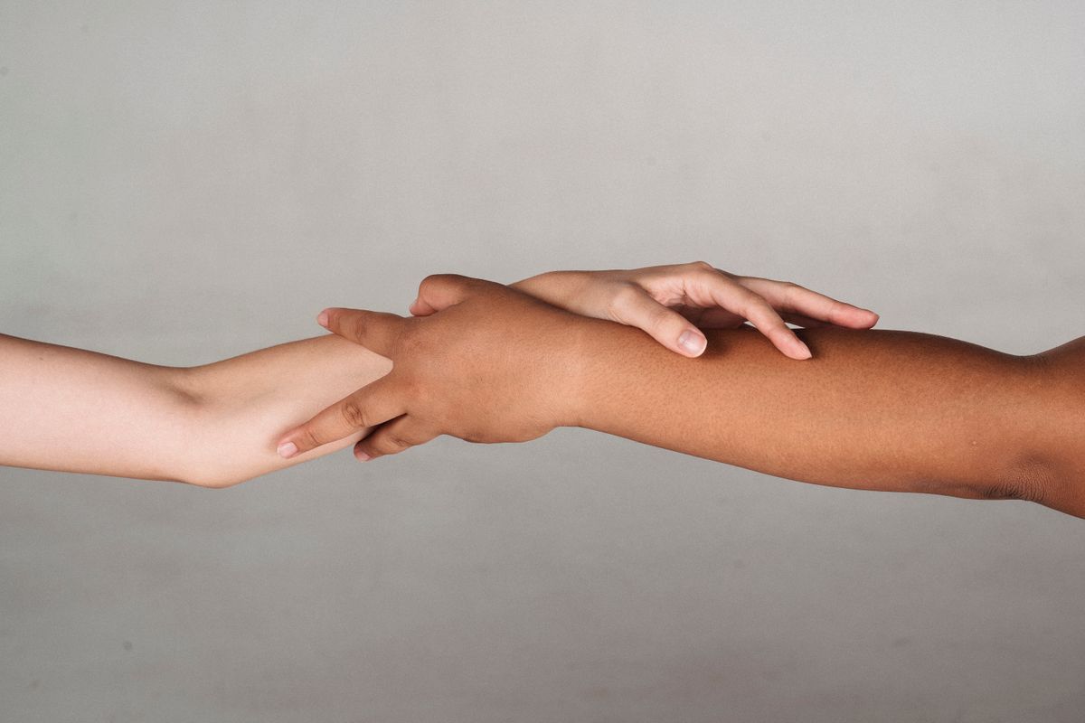 Two hands reaching toward each other
